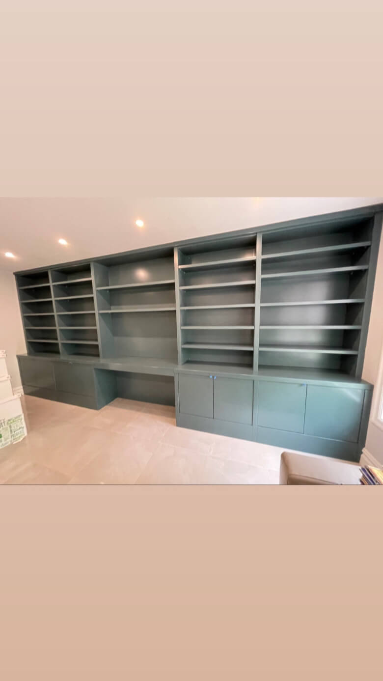 A large blue bookcase with two shelves and a desk.