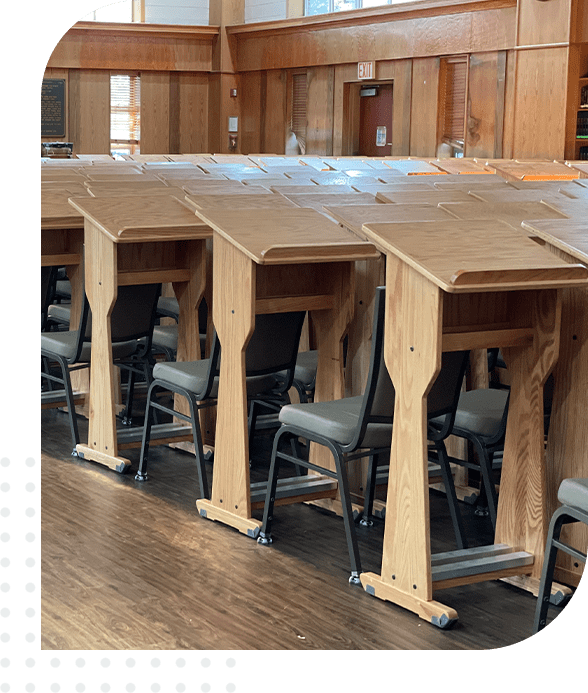 A row of desks with chairs in front.