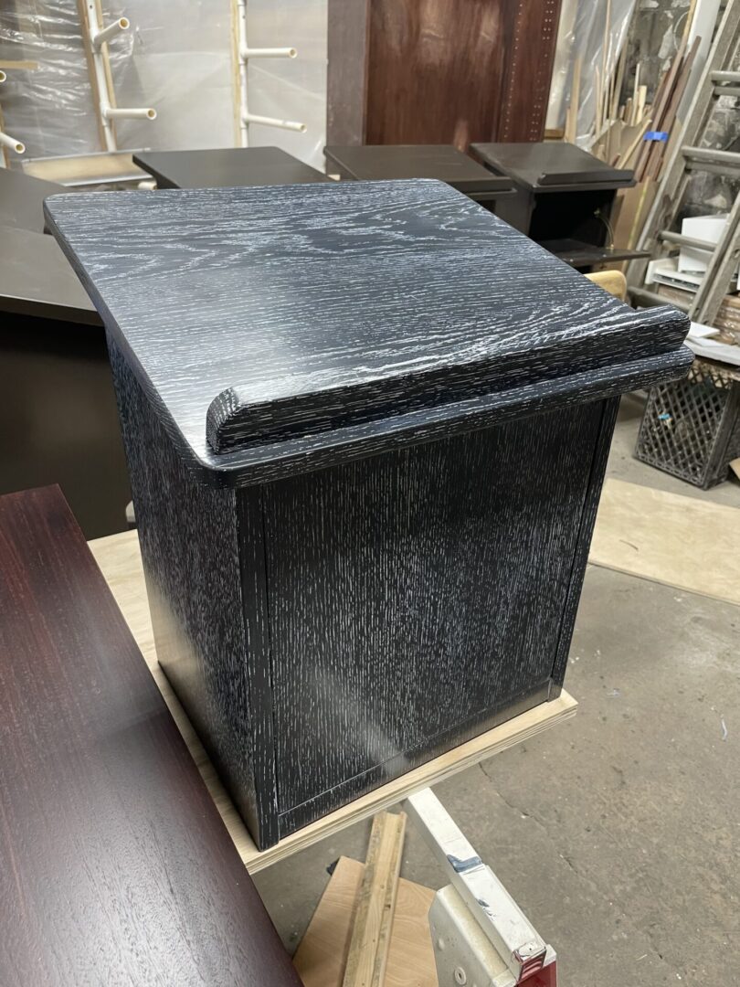 A black box sitting on top of a piece of wood