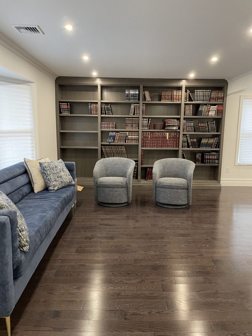 A living room with a blue couch and bookshelves